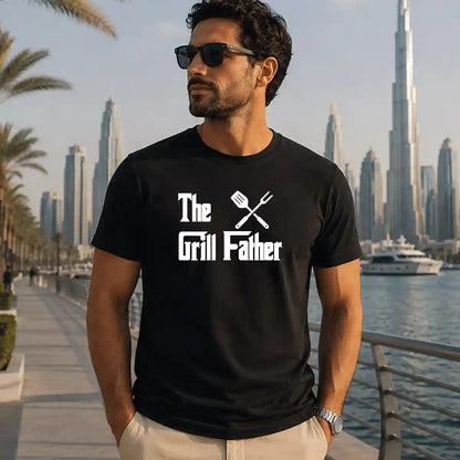 Man wearing black "The Grill Father" barbecue t-shirt with grilling utensils graphic, funny BBQ dad gift, Dubai UAE.